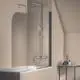 Duschsystem von Ideal Standard mit Wandmontage, inklusive Handdusche und Rainshower, neben einer Badewanne in einem Raum mit beige gestrichenen Wänden.